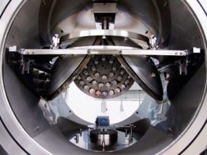 alt = Close up of an E-beam planetary system showing the internal variety of fixtures and central platform in a metal chamber. This is designed for electron beam processing with precise manufacturing.